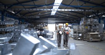Factory workers in industrial production hall.